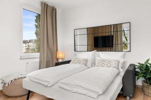 1 dormitorio blanco con 2 camas y ventana en SoWi Design - Gartenblick & Parkplatz, Küche, en Kassel