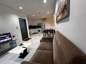 a living room with a couch and a tv in it at Summer Suites KLCC By Homestay in Kuala Lumpur