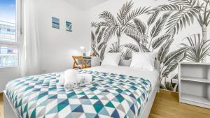 - une chambre avec un grand lit orné d'une fresque murale de palmiers dans l'établissement COLOC LAGON - Belle Colocation haut de gamme de 3 chambres / Proche Gare / Parking gratuit / Balcon / Wifi & Netflix, à Ville-la-Grand