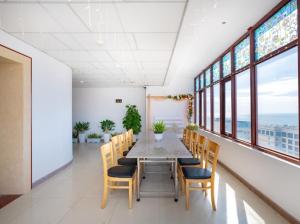 uma sala de jantar com mesa, cadeiras e janelas em KHÁCH SẠN SƠN THỊNH 23D THÙY VÂN em Vung Tau