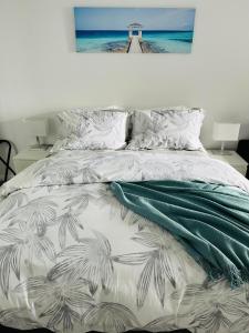1 dormitorio con 1 cama con una pintura en la pared en Shellharbour Haven, en Shellharbour