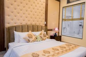 ein Schlafzimmer mit einem großen Bett und einem Fenster in der Unterkunft Le Haute Hotel Hai Phong in Haiphong