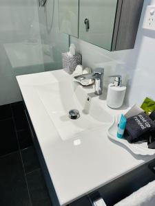 a bathroom with a white sink and a mirror at Shellharbour Haven in Shellharbour