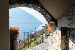 a view from the balcony of a house with a clock at Unique Gandria 3 by Quokka 360 - luxury two-bedroom apartment with a breathtaking view in Lugano