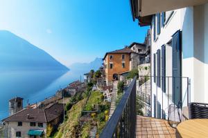 a view of a town from a balcony of a building at Unique Gandria 3 by Quokka 360 - luxury two-bedroom apartment with a breathtaking view in Lugano