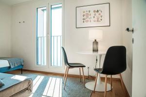 a room with two chairs and a table and a bed at Unique Gandria 3 by Quokka 360 - luxury two-bedroom apartment with a breathtaking view in Lugano
