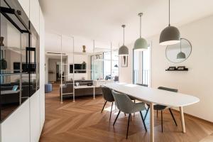 uma sala de jantar e sala de estar com uma mesa branca e cadeiras em Unique Gandria 3 by Quokka 360 - luxury two-bedroom apartment with a breathtaking view em Lugano