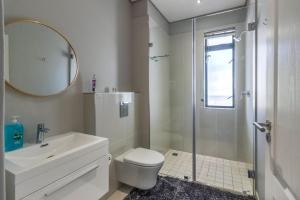 a bathroom with a shower and a toilet and a sink at Crossfire @ Home in Somerset West