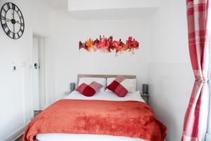 a bedroom with a bed with a red blanket at Trinity, Central Cambridge Flat in Cambridge