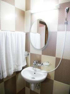 y baño con lavabo, espejo y toallas. en Marianas Guesthouse en Obzor