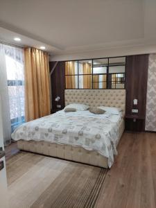- une chambre avec un grand lit et une grande fenêtre dans l'établissement Hotel Villa Natali, à Chişinău
