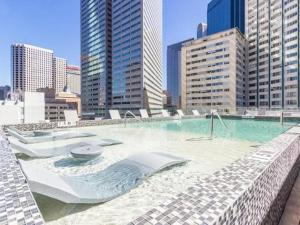 a large swimming pool in a city with tall buildings at On The Go Stays in Dallas