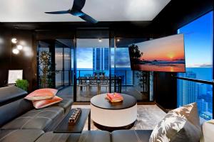 uma sala de estar com um sofá e uma televisão de ecrã plano em 2 Bedroom Apartment with Ocean Views - Circle on Cavill - Self Contained, Privately Managed em Gold Coast