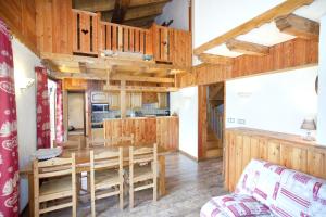 贝桑Chalet l'aubépine résidence B&B的配有桌椅的厨房和餐厅
