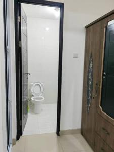 a bathroom with a toilet and a glass door at Sweet City Villa near Mall Pekanbaru Sudirman in Pekanbaru