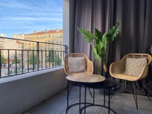 2 Stühle und ein Tisch auf einem Balkon mit Aussicht in der Unterkunft Cosy flat Marseille Joliette, secured parking lot in Marseille