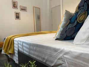 ein Bett mit blauen und weißen Kissen darauf in der Unterkunft Cosy flat Marseille Joliette, secured parking lot in Marseille