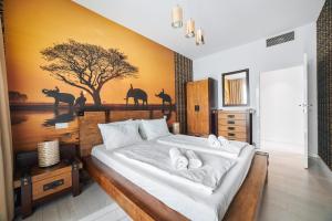 a bedroom with a large bed with a painting on the wall at Apartament B225 - Dune Beach Resort in Mielno