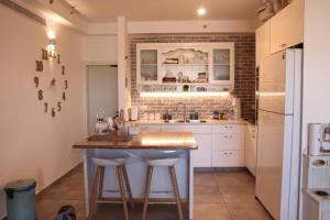 uma cozinha com um balcão, um lavatório e um frigorífico em דירת בוטיק כיפית לשומרי שבת וכשרות בלבד em Ra‘ananna