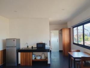 Una cocina con fregadero y encimera con microondas. en The Sila Suites - Intrawarorot, en Chiang Mai
