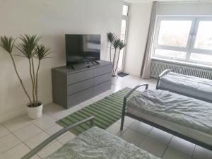 a living room with a flat screen tv and a bed at Apartment with Balcony in Mönchengladbach in Mönchengladbach