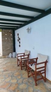 two wooden benches sitting on a stone patio at Villa Ioanna in Kalamitsi