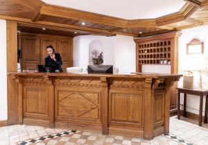 a woman is sitting at a wooden counter in a room at Les Peupliers in Courchevel