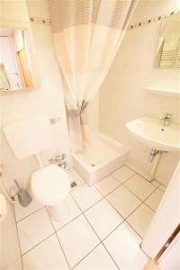 bagno bianco con servizi igienici e lavandino di Ferienpark - Haus A, App 0A0704 a Heiligenhafen