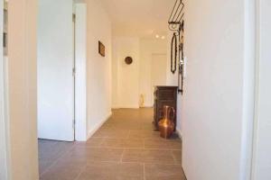 a hallway with a door and a tile floor at Knurrhahn, Wohnung EG, Dengler in Utersum