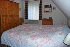 una camera con letto, armadi in legno e finestra di Haus Severin Whg Rother mit Balkon Nr 4 a Goting