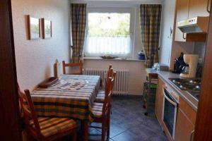 una cucina con tavolo, sedie e finestra di Haus Severin Whg Rother mit Balkon Nr 4 a Goting Altre 3 foto
