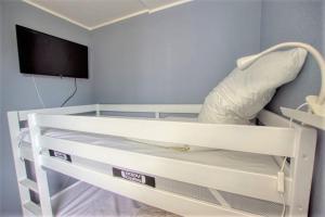 Cette chambre dispose de lits superposés blancs et d'une télévision. dans l'établissement Ferienpark - Haus A, App 0AEG06, à Heiligenhafen