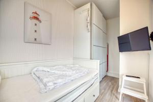 ein weißes Zimmer mit einem Bett und einem Leuchtturm an der Wand in der Unterkunft Ferienpark - Haus A, App 0AEG08 in Heiligenhafen