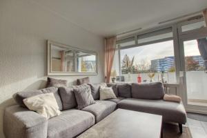 - un salon avec un canapé et une grande fenêtre dans l'établissement Ferienpark - Haus A, App 0AEG08, à Heiligenhafen