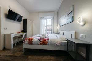 维罗纳Porta Nuova Suites的一间卧室，配有一张床、一张书桌和一扇窗户