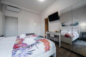Schlafzimmer mit einem Bett, einem Schreibtisch und einem Spiegel in der Unterkunft Porta Nuova Suites in Verona