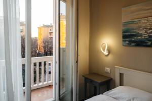 维罗纳Porta Nuova Suites的一间卧室配有一张床,阳台设有窗户 更多32张照片