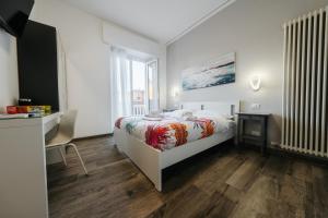 ein weißes Schlafzimmer mit einem Bett und einem Schreibtisch in der Unterkunft Porta Nuova Suites in Verona