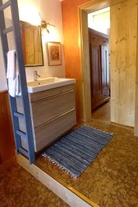 y baño con lavabo, espejo y alfombra. en Ecologis du Vignoble en Katzenthal