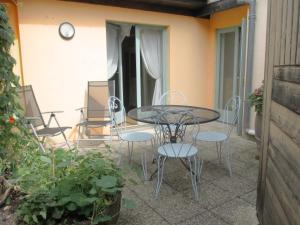 patio ze stołem i krzesłami na balkonie w obiekcie Ecologis du Vignoble w mieście Katzenthal