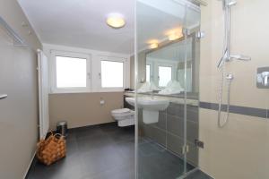 a bathroom with a shower and a toilet and a sink at Haus Sarah App 06 in Westerland