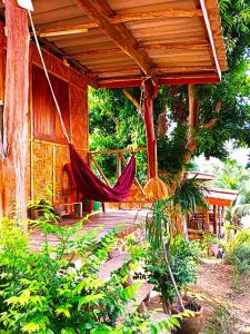 a hammock hanging from a porch of a house at Asama Bungalow in Ko Lanta