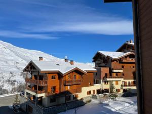a large apartment building with snow on the roof at CHALET DES CIMES in Les Menuires