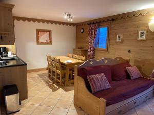 a kitchen and a living room with a couch and a table at CHALET DES CIMES in Les Menuires