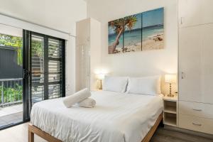 a bedroom with a bed and a large window at Julians Apartments in Byron Bay