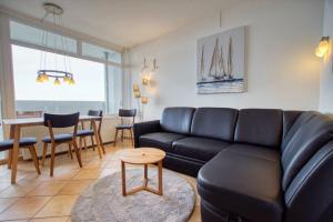 sala de estar con sofá de cuero negro y mesa en Ferienpark - Haus B, App 0B0606, en Heiligenhafen