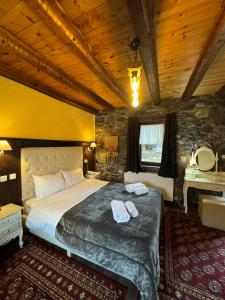 a bedroom with a large bed with towels on it at Chalet Asteras tou Vorra in Palaios Agios Athanasios