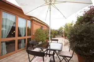 羅馬的住宿－Marconi Penthouse，庭院内桌椅和遮阳伞
