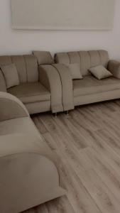 a living room with a couch and wooden floors at النقره خلف العثيم مول 4 in Hail