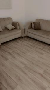 uma sala de estar com 2 sofás e um piso de madeira em النقره خلف العثيم مول 4 em Hail